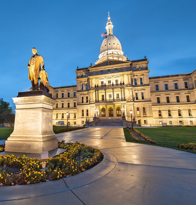 Michigan parliament building behind a statue