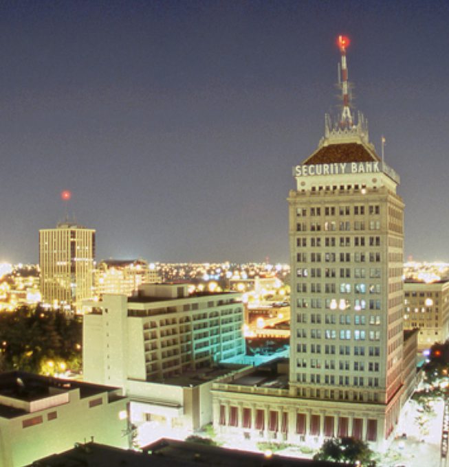 Night view of United Security Bank building in Fresno, CA, with cityscape background