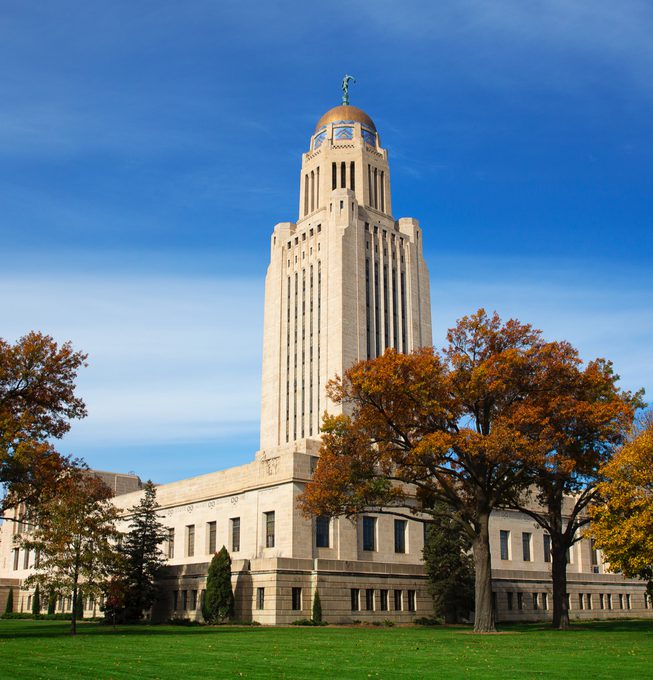 Nebraska State Legislature building amid blooming trees