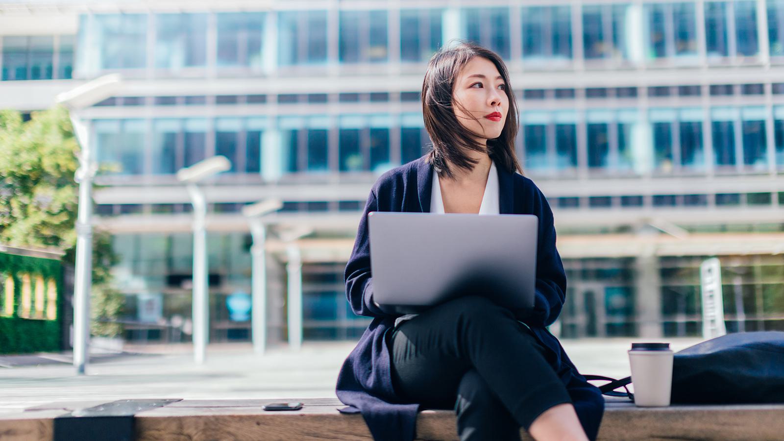 Woman on computer outside office building