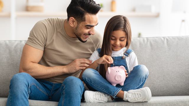 Father and Daughter with a Piggy Bank